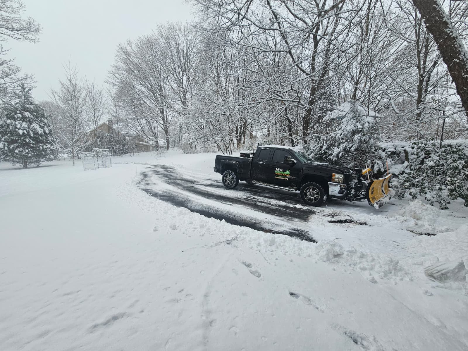 Snow plowing service clearing residential driveway for safe winter access in Connecticut.