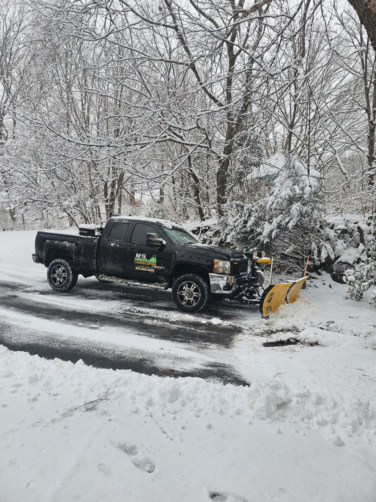 Snow plowing service clearing residential driveway for safe winter access in Connecticut.
