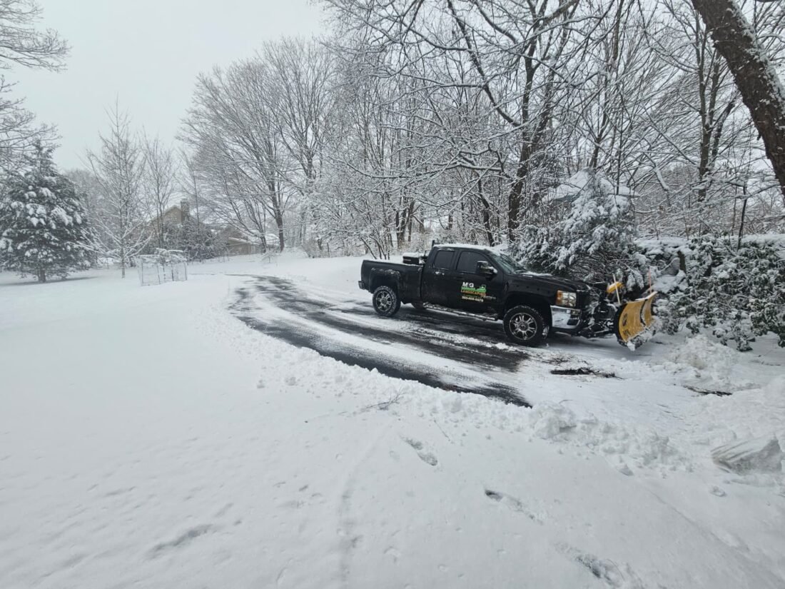 Snow plowing service clearing residential driveway for safe winter access in Connecticut.